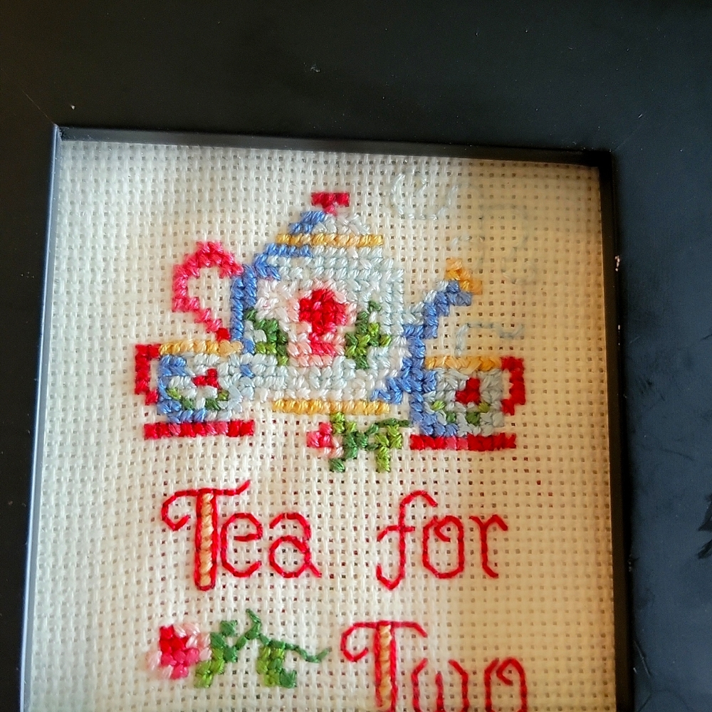 Cottagecore Cross-stitch "Tea for Two" mounted in black frame.